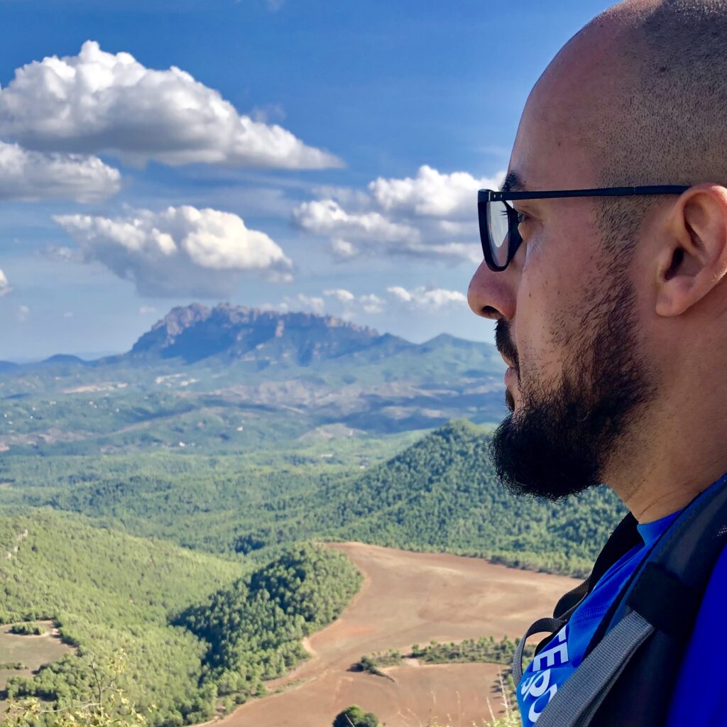 Miky Armengol mirando al horizonte con las montañas de Montserrat de fondo.